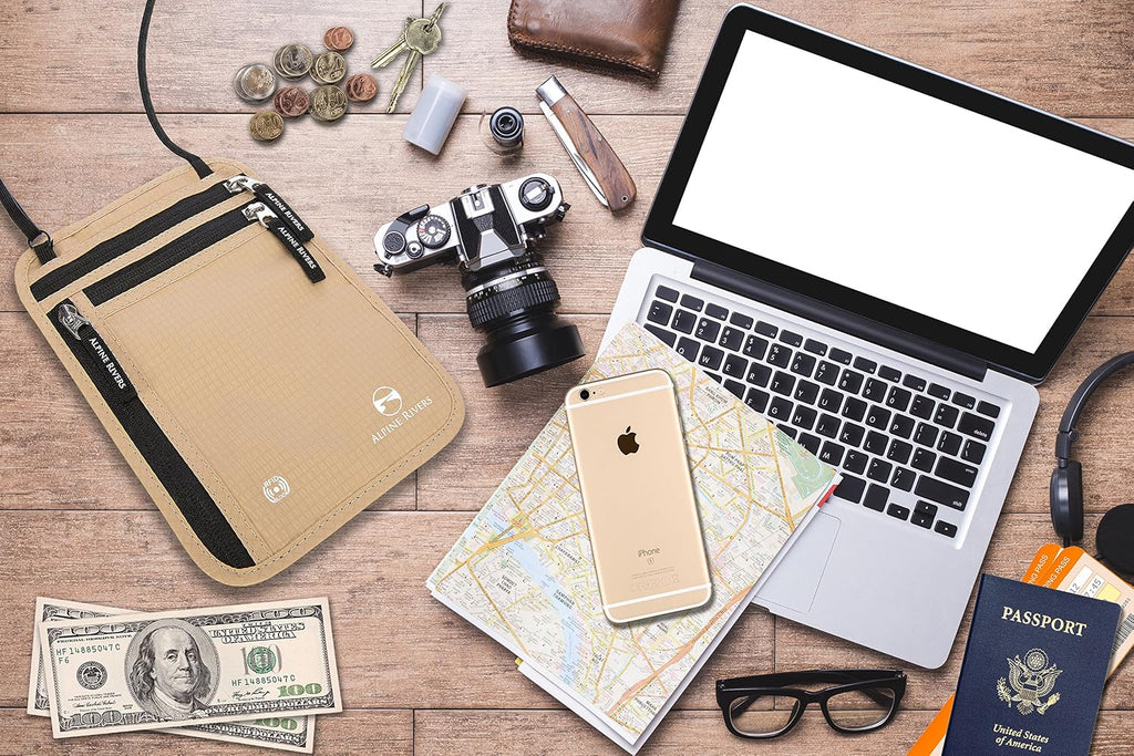 Neck wallet flat-laid with a passport, camera, laptop, map and cash for travel.
