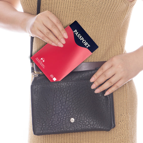 Red Alpine Rivers RFID blocking passport protector sliding into a handbag, from the Multi-Color sleeve pack